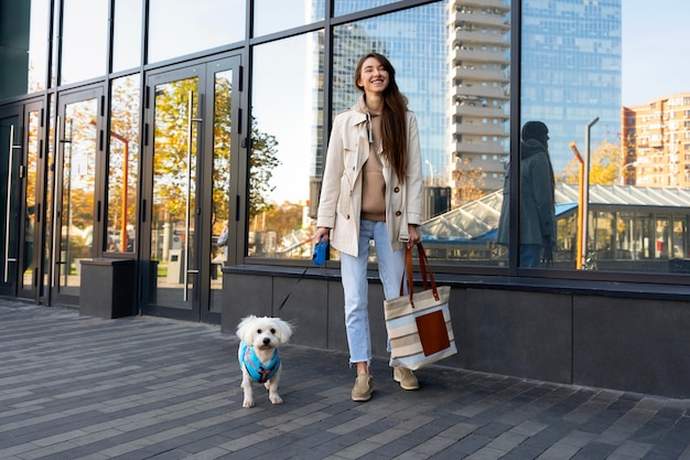 Foto grátis mulher sorridente de tiro completo com cachorro fofo