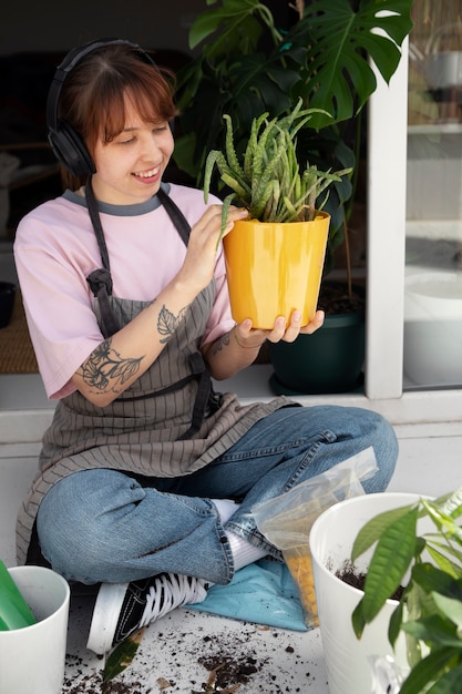 Mulher sorridente de tiro completo com plantas