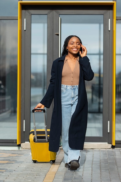 Foto grátis mulher sorridente de tiro completo falando no telefone