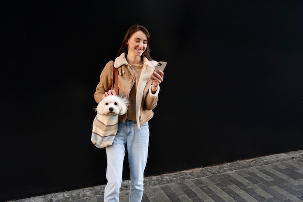 Foto grátis mulher sorridente de tiro completo segurando smartphone