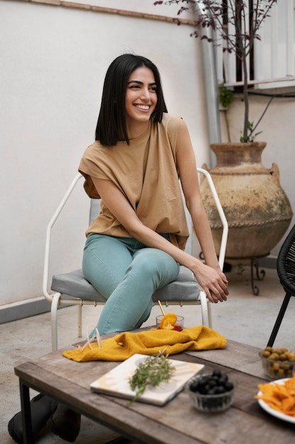 Foto grátis mulher sorridente de tiro completo sentada na cadeira