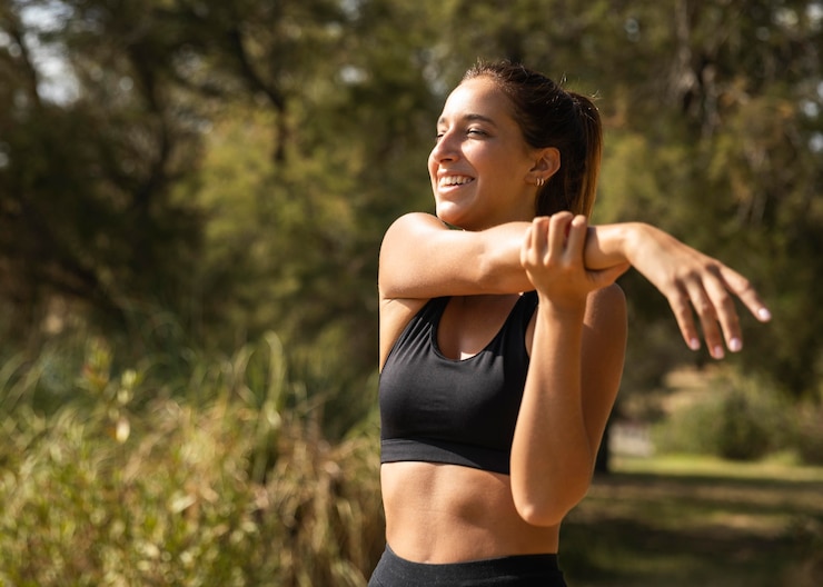 Foto grátis mulher sorridente de tiro médio alongando-se