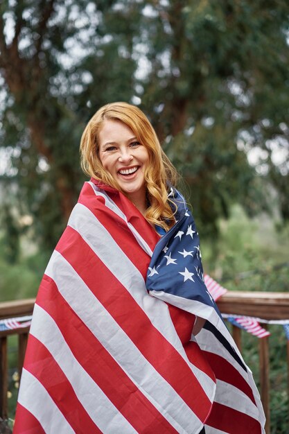 Mulher sorridente de tiro médio com bandeira dos eua