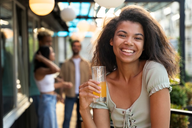 Mulher sorridente de tiro médio com bebida