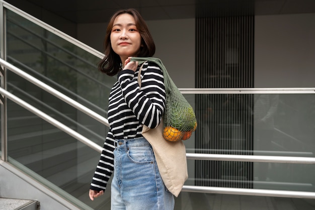 Mulher sorridente de tiro médio com bolsa de tecido