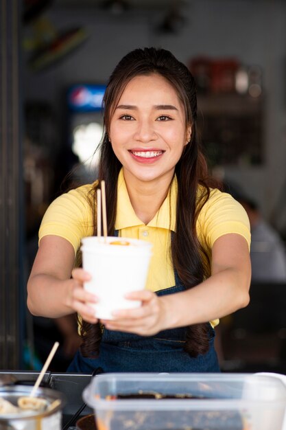 Mulher sorridente de tiro médio com comida