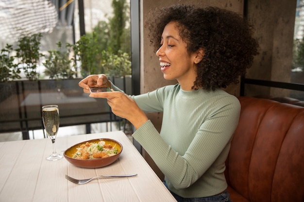 Mulher sorridente de tiro médio com comida