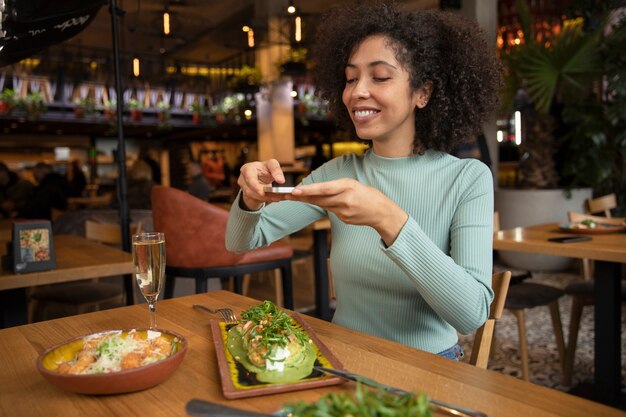 Mulher sorridente de tiro médio com comida