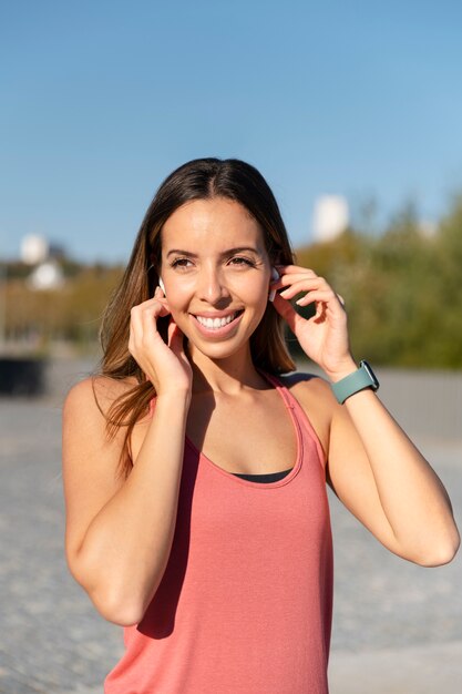 Mulher sorridente de tiro médio com fones de ouvido