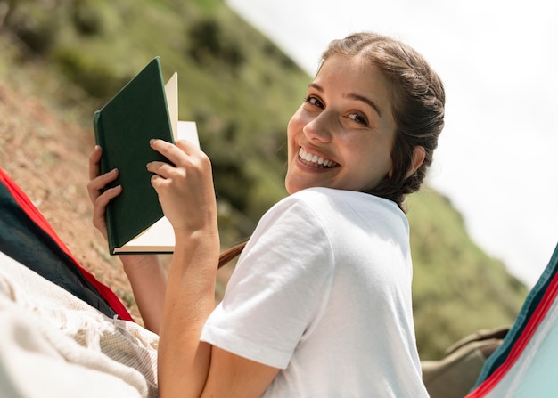 Mulher sorridente de tiro médio com livro