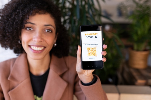 Foto grátis mulher sorridente de tiro médio com passaporte de vacinação