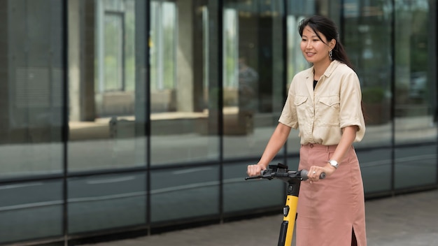 Foto grátis mulher sorridente de tiro médio com scooter