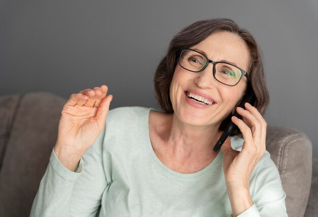 Mulher sorridente de tiro médio com telefone