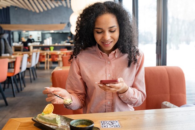 Mulher sorridente de tiro médio digitalizando qr