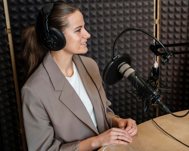 Mulher sorridente de tiro médio falando no rádio