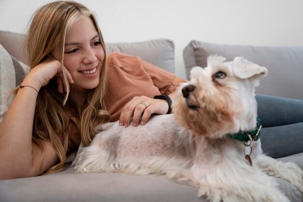 Mulher sorridente de tiro médio fazendo carinho em cachorro
