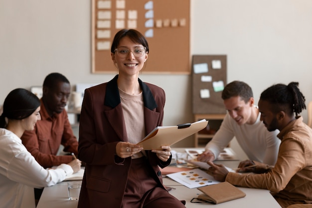 Foto grátis mulher sorridente de tiro médio no trabalho