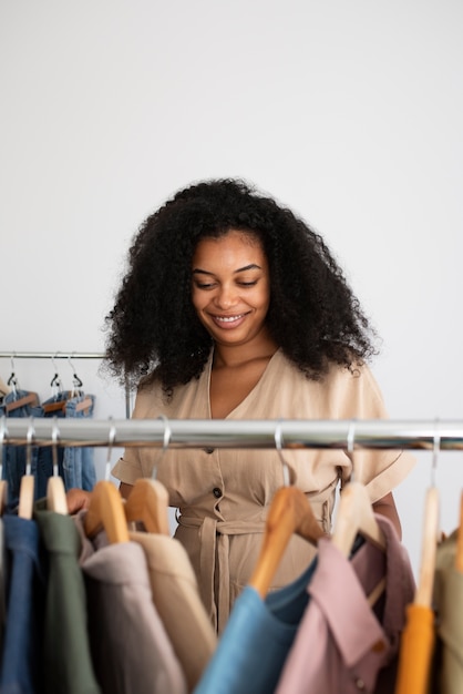 Mulher sorridente de tiro médio olhando roupas