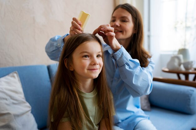 Mulher sorridente de tiro médio, penteando o cabelo