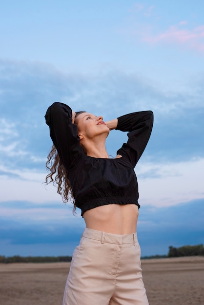 Foto grátis mulher sorridente de tiro médio posando ao ar livre