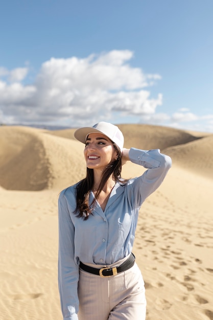 Mulher sorridente de tiro médio posando no deserto