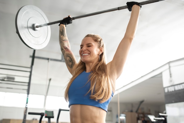 Foto grátis mulher sorridente de tiro médio segurando a barra