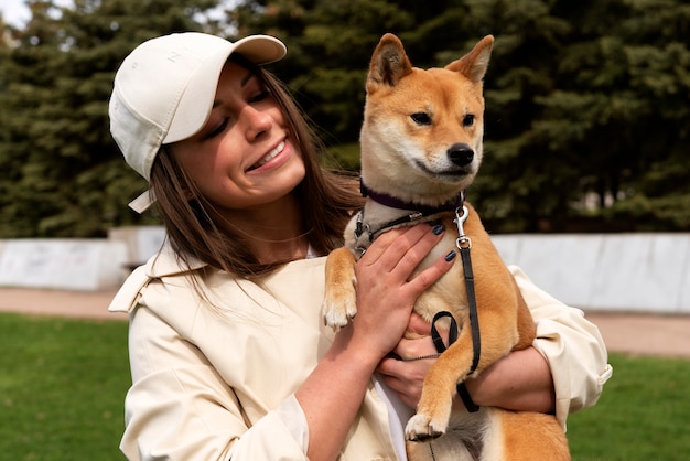 Foto grátis mulher sorridente de tiro médio segurando cachorro fofo