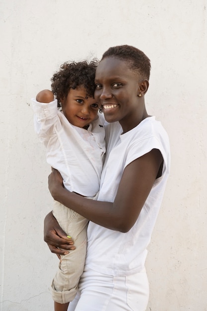 Foto grátis mulher sorridente de tiro médio segurando criança