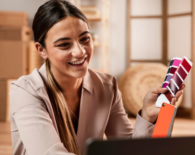 Mulher sorridente de tiro médio segurando paleta de cores