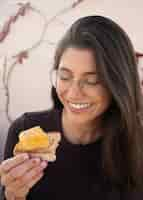 Foto grátis mulher sorridente de tiro médio segurando tortilla espanhola