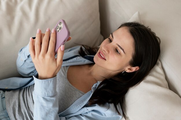 Mulher sorridente de tiro médio segurando um smartphone