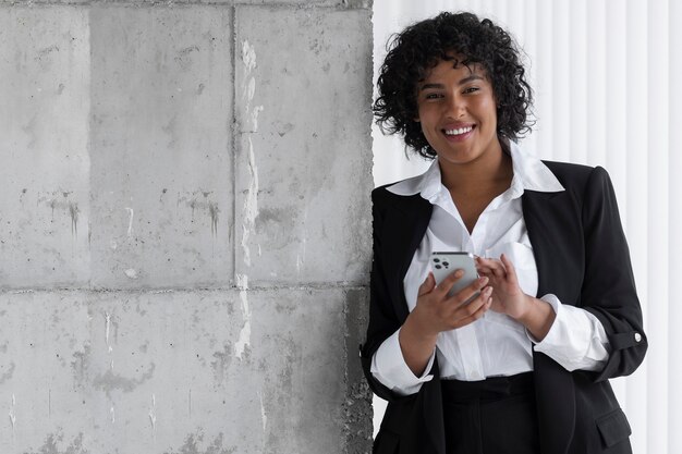 Mulher sorridente de tiro médio segurando um smartphone