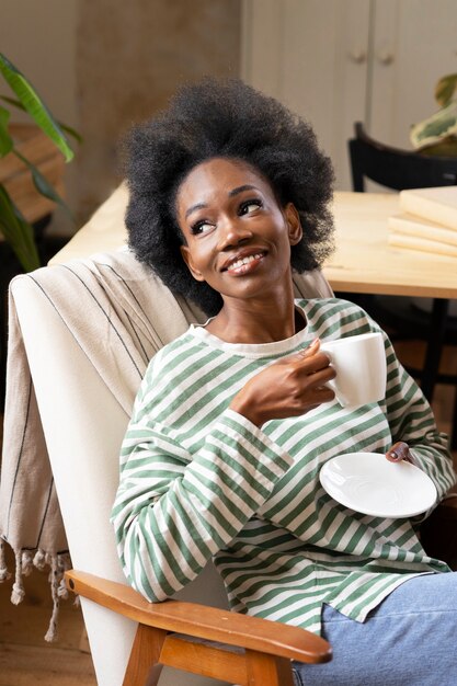 Mulher sorridente de tiro médio tomando café