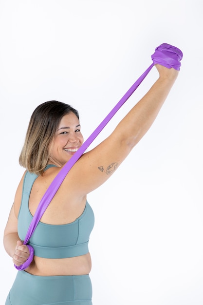 Foto grátis mulher sorridente de tiro médio treinando com banda