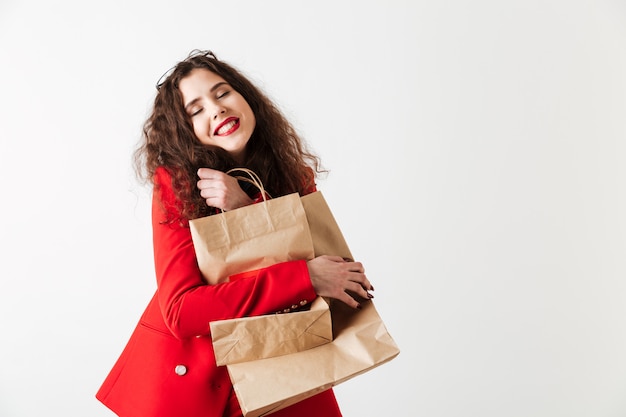 Mulher sorridente de venda segurando sacolas de compras