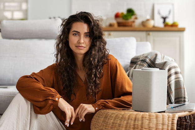 Foto grátis mulher sorridente de vista frontal com alto-falante inteligente