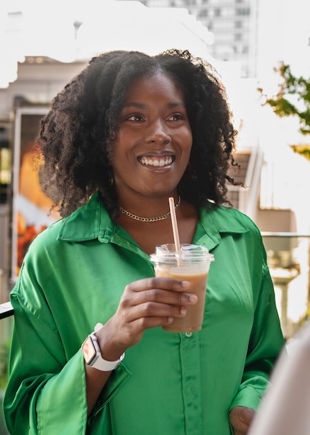 Foto grátis mulher sorridente de vista frontal com café gelado