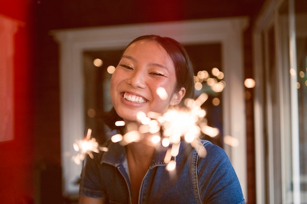 Mulher sorridente de vista frontal com fogos de artifício