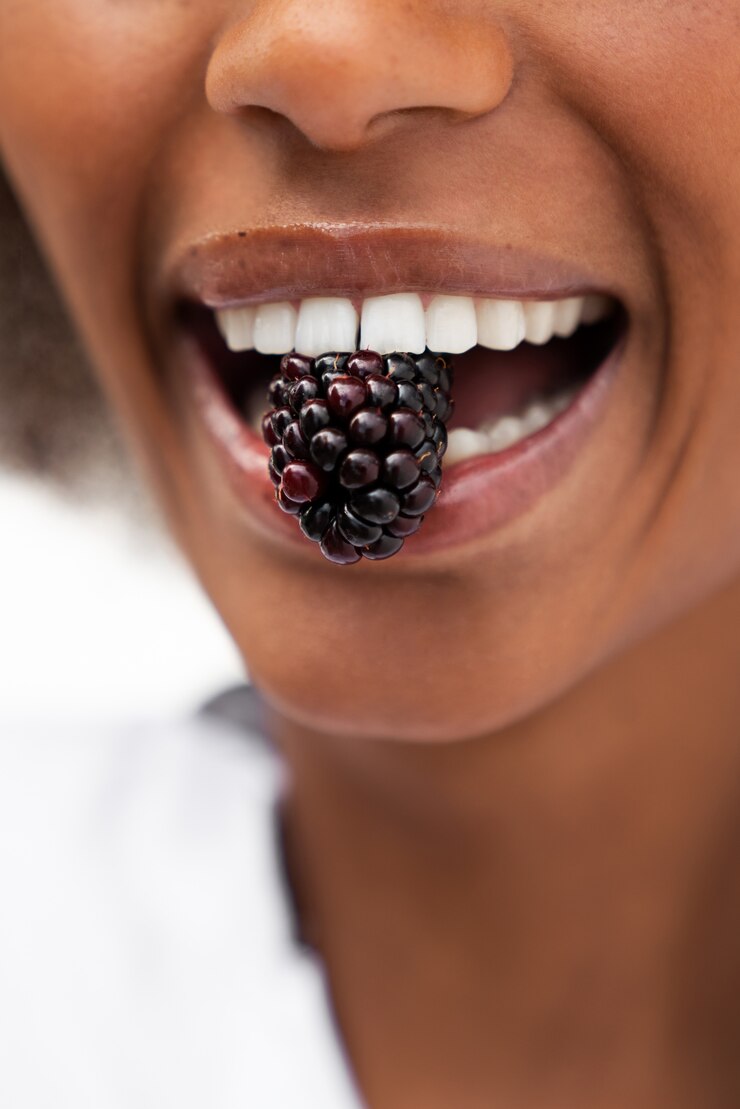 Foto grátis mulher sorridente de vista frontal comendo amoras