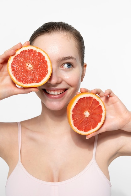 Foto grátis mulher sorridente de vista frontal segurando toranja