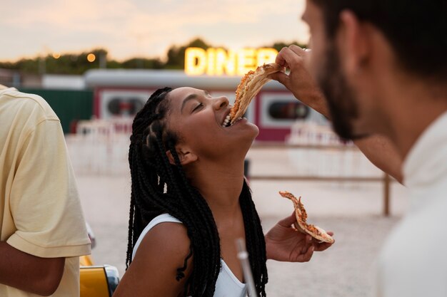 Mulher sorridente de vista lateral comendo pizza