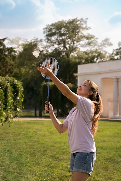 Foto grátis mulher sorridente de vista lateral jogando badminton