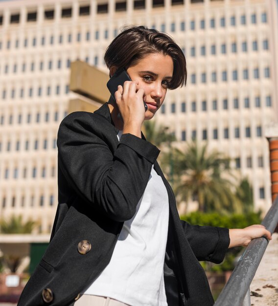 Mulher sorridente e elegante falando ao telefone