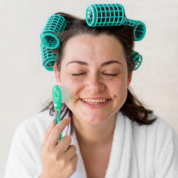 Foto grátis mulher sorridente em close-up escovando rosto