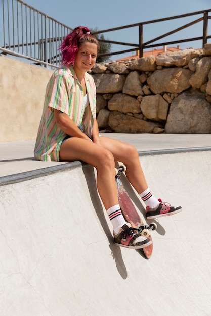 Mulher sorridente em foto completa com skate