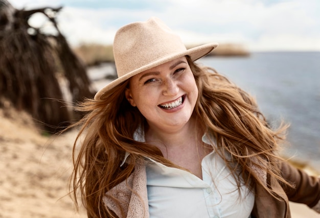 Mulher sorridente em foto média à beira-mar