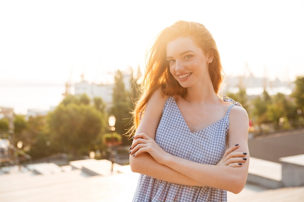 Mulher sorridente em pé com os braços cruzados