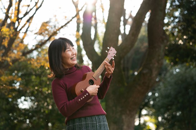 Mulher sorridente em tiro médio tocando cavaquinho