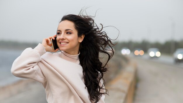 Mulher sorridente, falando no celular