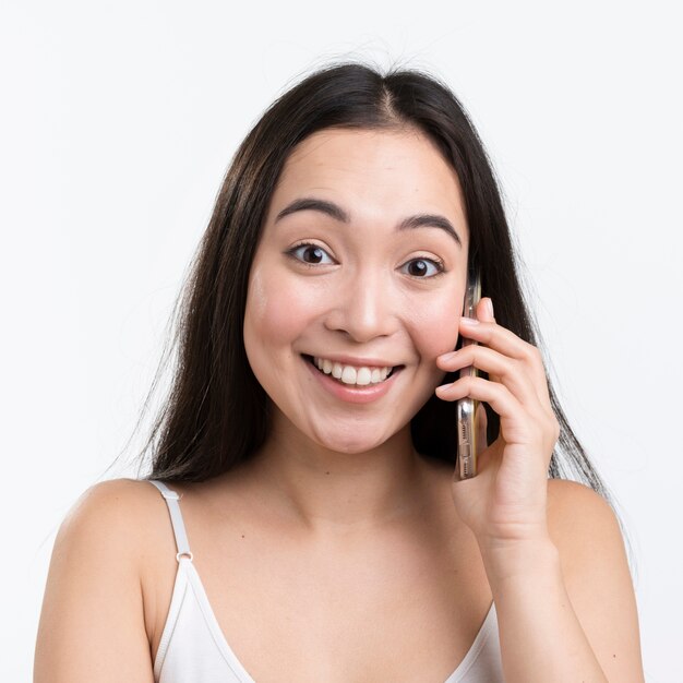 Mulher sorridente, falando por telefone